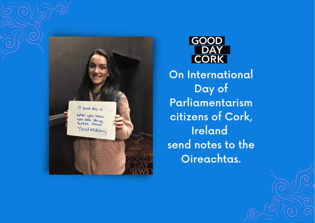 Text reads: On International Day of Parliamentarism citizens of Cork, Ireland send notes to the Oireachtas with photograog of girl holding a sign that reads A good day is when you're doing better than yesterday.