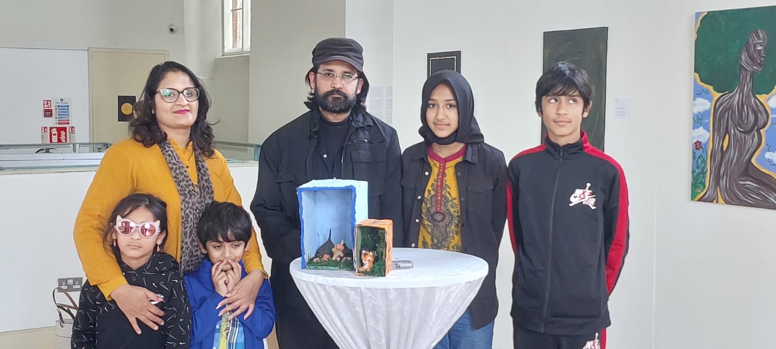 Meher Walayat ArchiveOfOurYouth artist standing with their family and their art